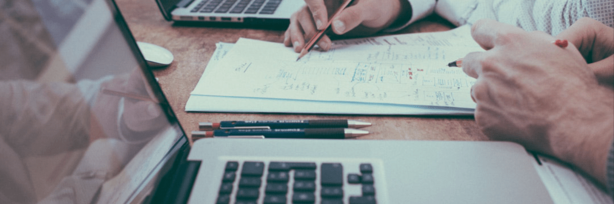 Digital marketing research done on desk in front of laptops
